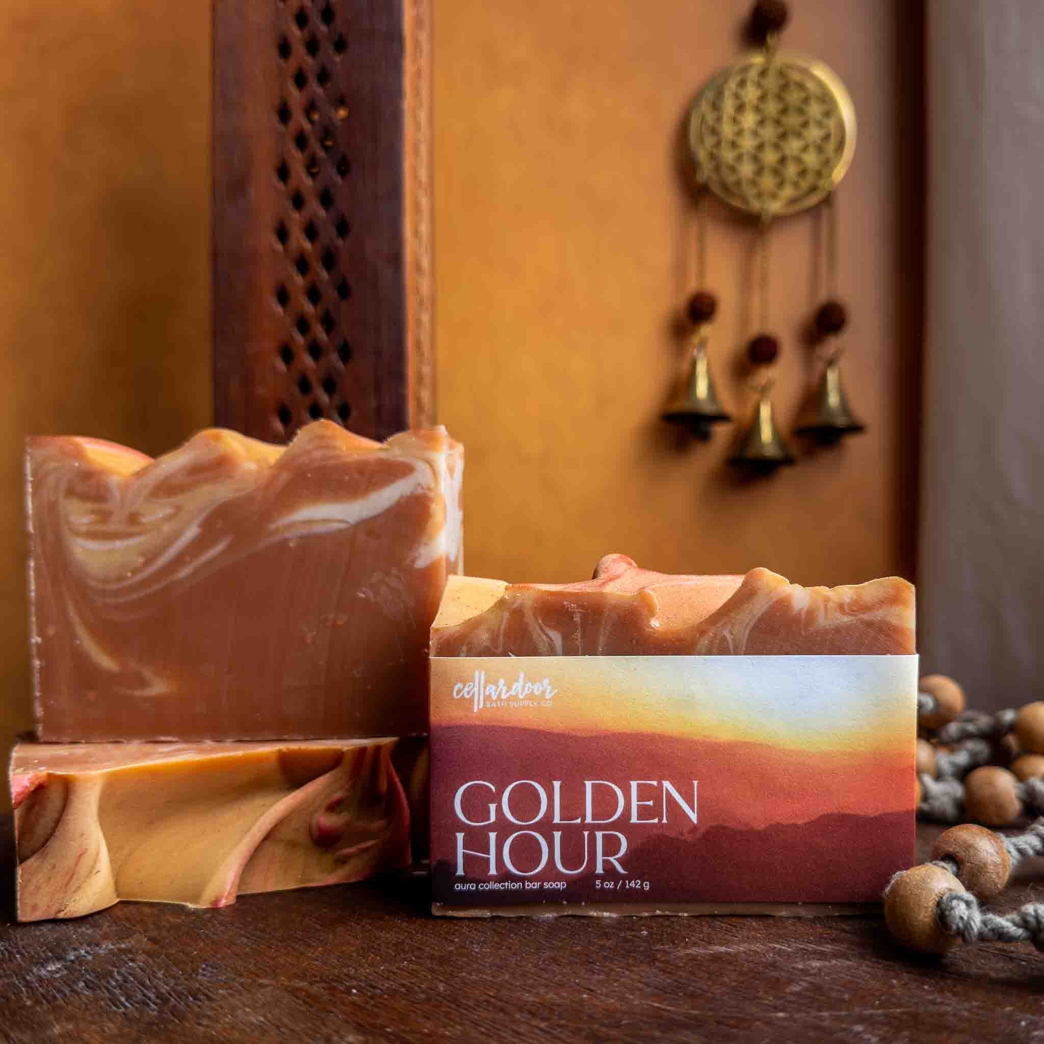 Bar of soap with packaging labeled 'Golden Hour' on a wooden surface with decorative elements.