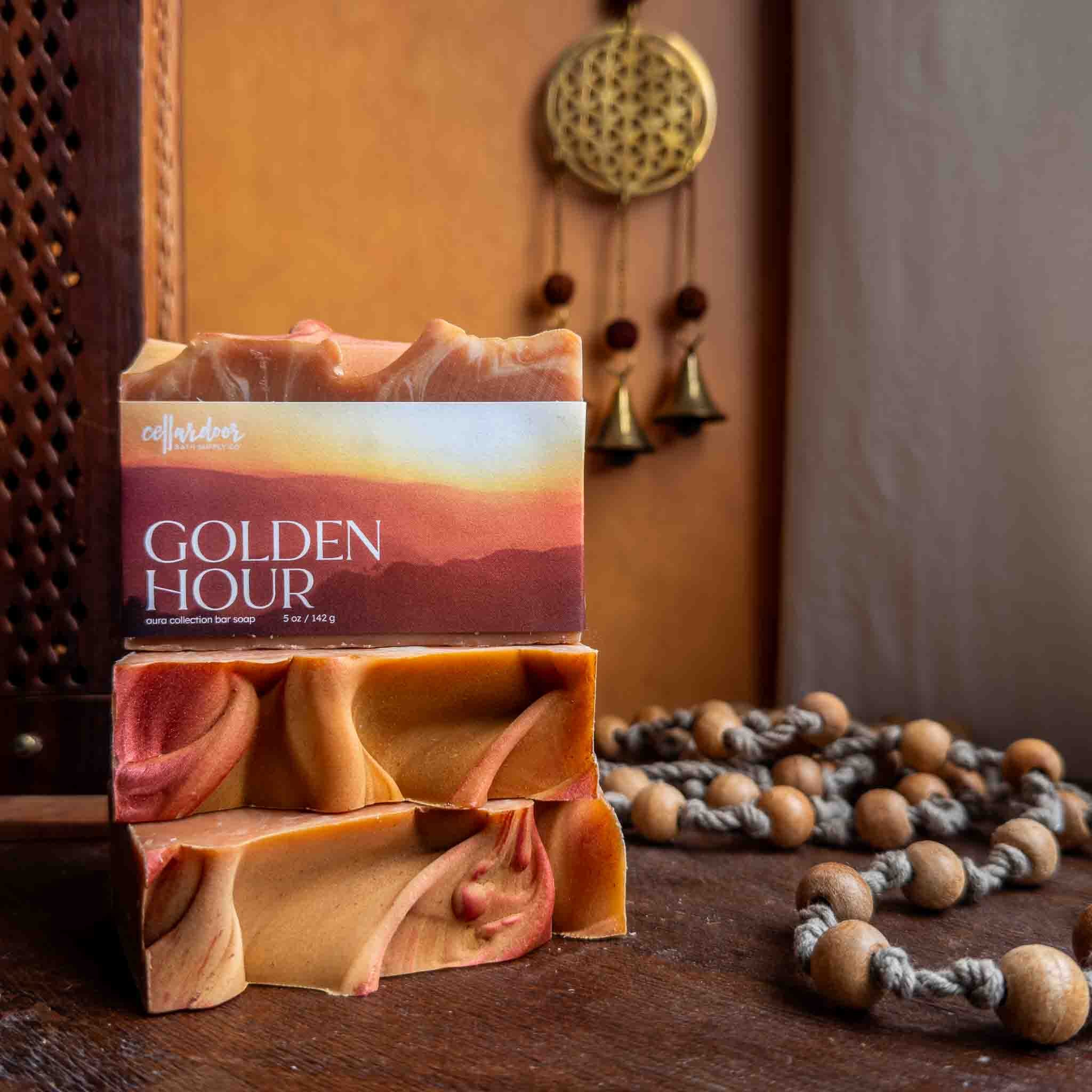 Bar of soap with packaging labeled 'Golden Hour' on a wooden surface with decorative elements.