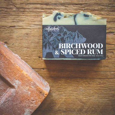 Bar of soap with a woodsy design packaging labeled 'Birchwood & Spiced Rum'.